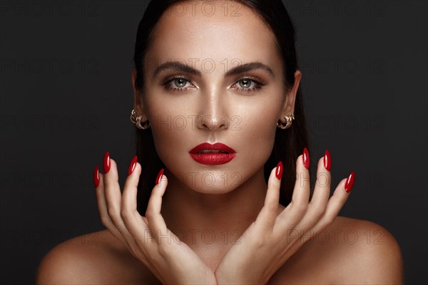 Beautiful girl with a classic make up and multi-colored nails. Manicure design. Beauty face. Photo taken in the studio