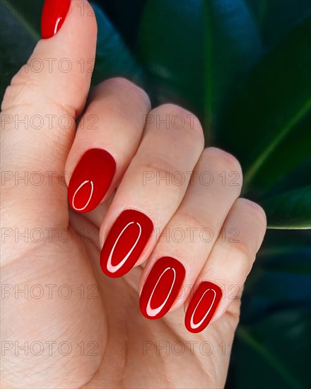 Bright festive red manicure on female hands. Nails design