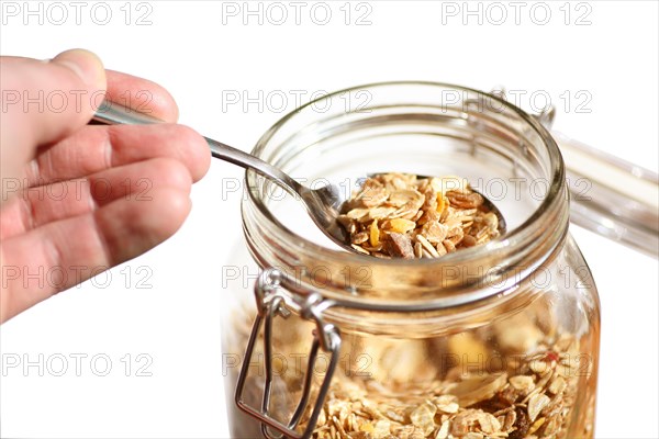 Spooning muesli from a glass