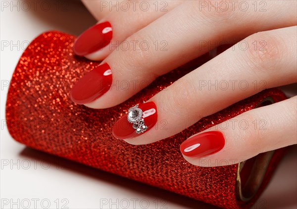 Bright festive red manicure on female hands. Nails design