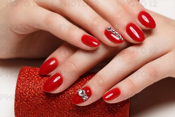 Bright festive red manicure on female hands. Nails design