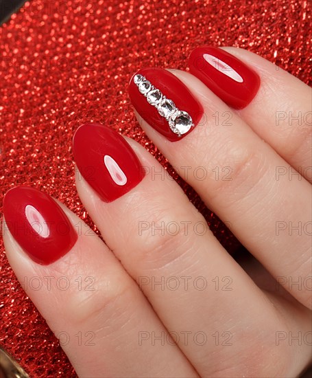 Bright festive red manicure on female hands. Nails design