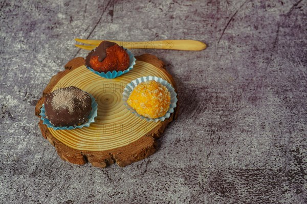 Truffles of different flavors on a wooden disk