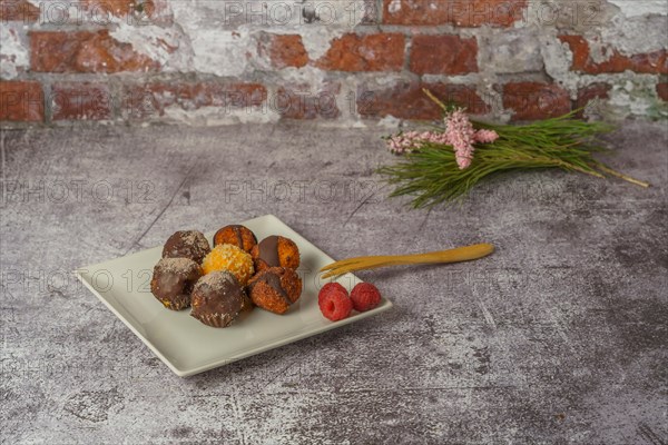 Sweet truffles of different flavors on a white ceramic plate