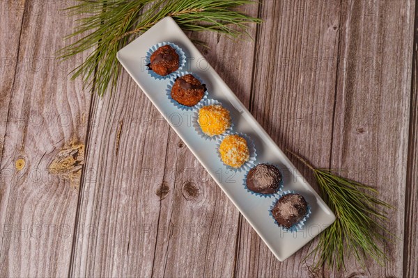 Sweet truffles in different flavors on a white ceramic tray