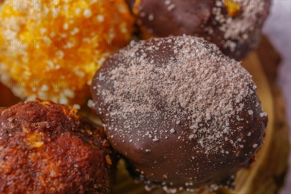 Close-up of sweet truffles of different flavors on a wooden disk