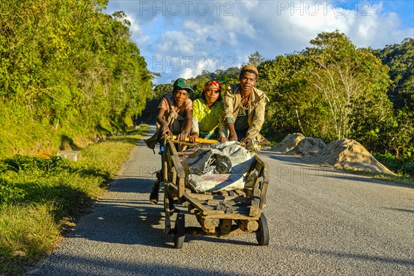 Young boys pushing self made carts up the hill