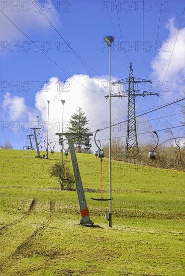 Ski lift at standstill due to lack of snow caused by climate change at the end of winter on a hill in Muensingen