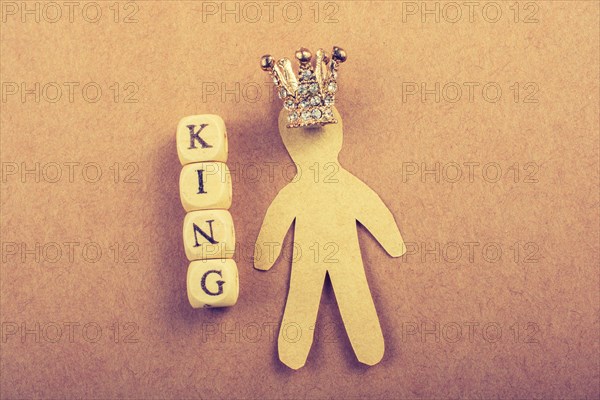 Tiny model crown beside the king wording on brown