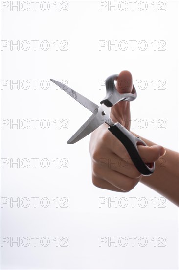 Hand holding steel scissors on a white backgruond