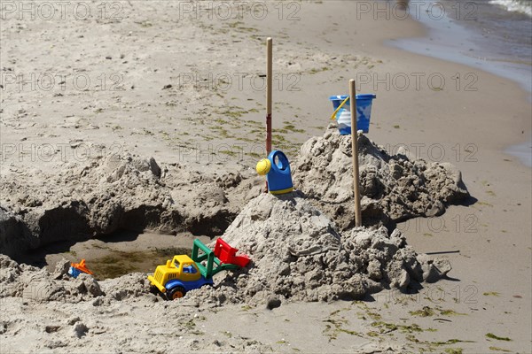 Toy and beach castle on a sandy beach by the sea