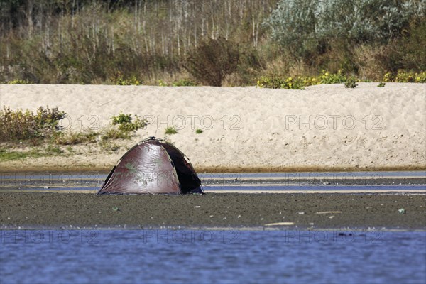 Camouflage tent of a nature photographer on a mudflat