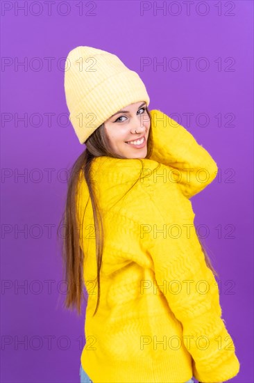 Close up portrait of a young caucasian woman in yellow wool sweater isolated on yellow background