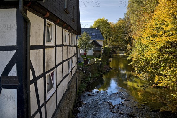 Half-timbered house with the river Roehr in Hachen with a marker for the Katharinen flood of 25 November 1890