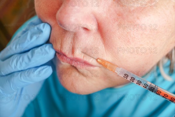 Older woman injected in lips Hyaluronic acid, Woman in beauty salon. plastic surgery clinic