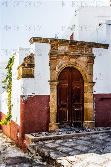 Old wooden doors with pebble mosaics on the floor, winding streets with white houses, Lindos, Rhodes, Greece, Europe