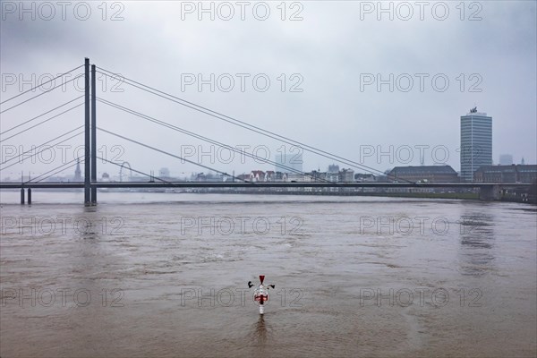 High water on the Rhine in Duesseldorf - Navigation sign at the harbour entrance with view of the Rheinkniebruecke and the old town, Duesseldorf, North Rhine-Westphalia, Germany, Europe