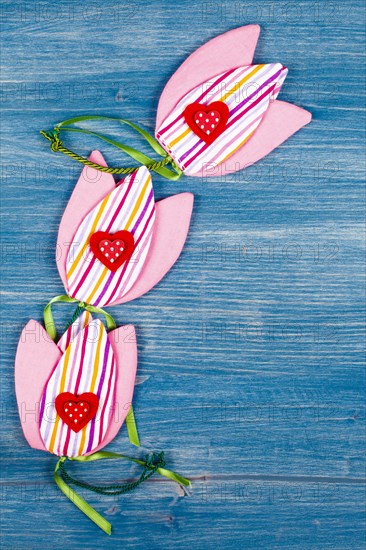 Three fabric tulips with three hearts on a blue background