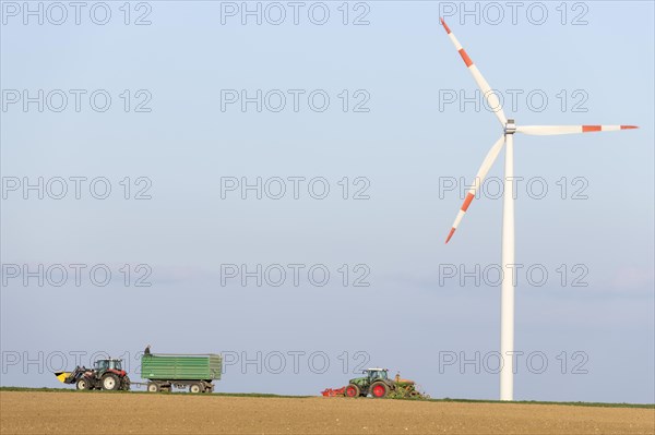 Tractor with trailer sowing grain in a field