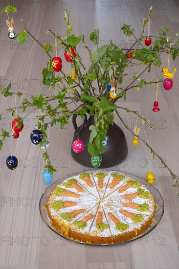 Homemade carrot cake in front of a shrub with Easter decorations