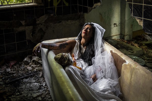 Deranged bride with a doll in a bathtub. Inspired by the traditional American legend of la llorona