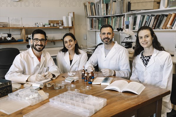 Group of scientists studying herbarium material seated at a common table in the laboratory. Teamwork. Research projects