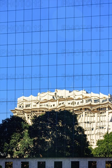 Commercial and business building with modern architecture and glass facade with reflection on the glass