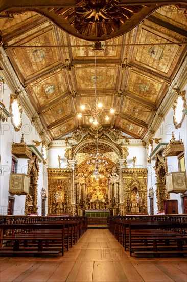 Interior and altar of a brazilian historic ancient church from the 18th century in baroque architecture with details of the walls in gold leaf in the city of Tiradentes