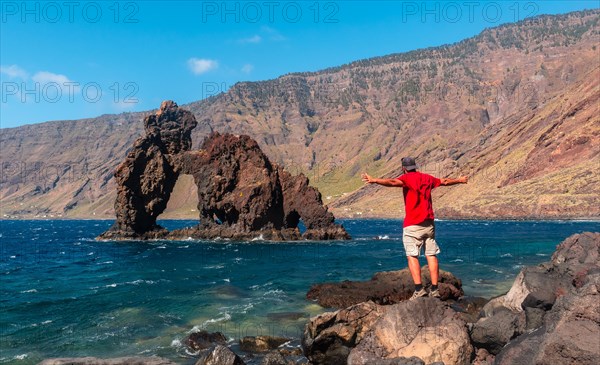 A young man in the touristic icon of El Hierro island called El Roque de la Bonanza