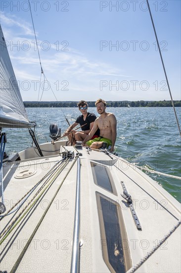 Two young men sailing on a sailboat