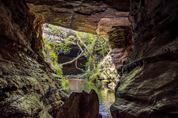 River running through stone cave in Carrancas rainforest in Minas Gerais