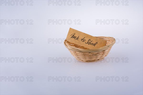 Back to school written on a note paper in a wooden basket