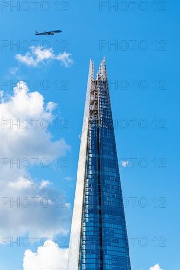 Airplane over a glass skyscraper