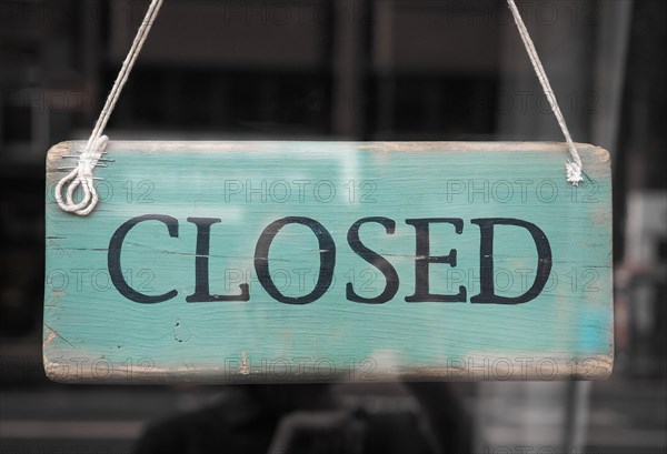 Closed sign in a shop showroom with reflections