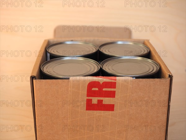 Fragile cardboard box with tin cans
