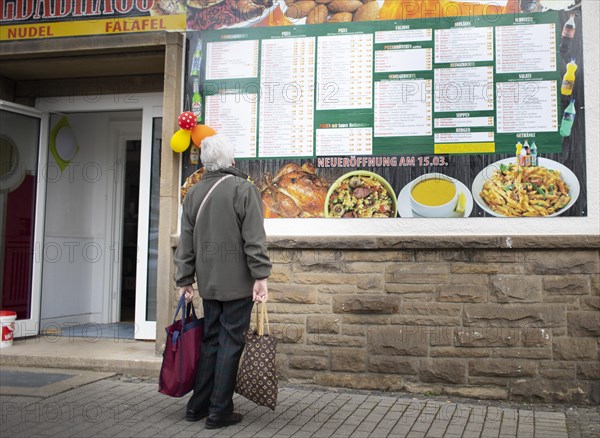 Subject: Pensioner in front of a fast food restaurant in times of lockdown