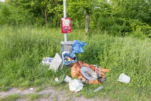 Destroyed rubbish bin with illegally deposited rubbish