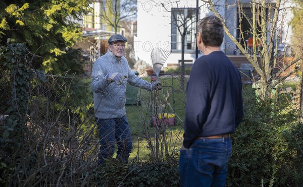 Topic: Neighbourhood. Dispute or conversation at the garden fence.