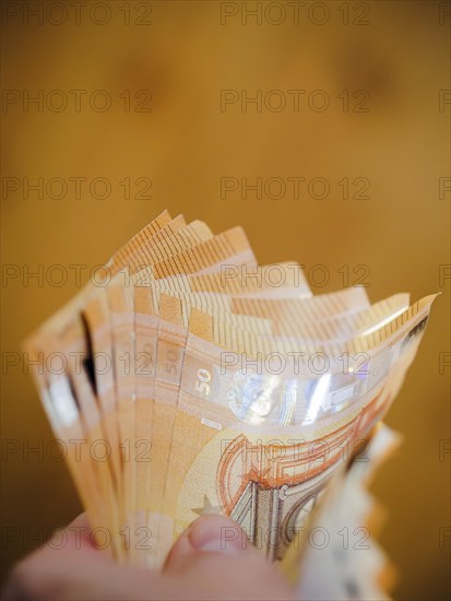 Symbolic photo on the subject of cash. 50 euro banknotes are held in one hand. Berlin