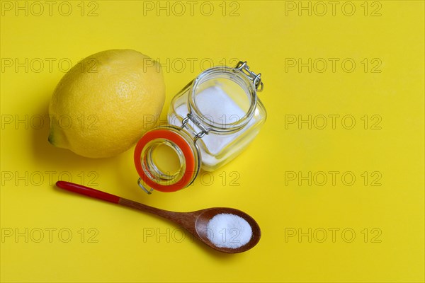 Citric acid in wooden spoon and glass container