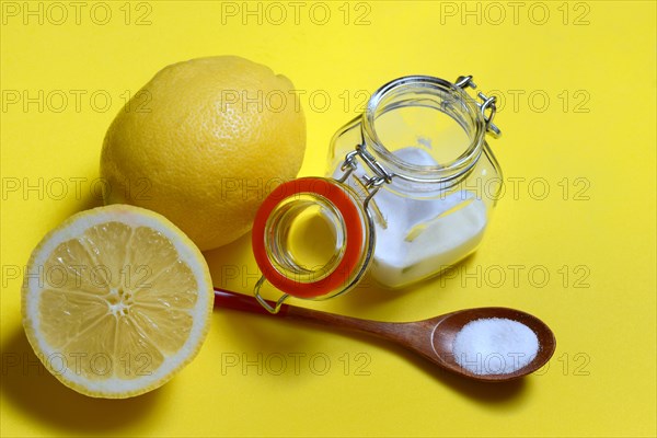 Citric acid in wooden spoon and glass container