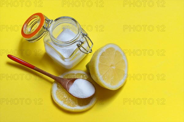 Citric acid in wooden spoon and glass container