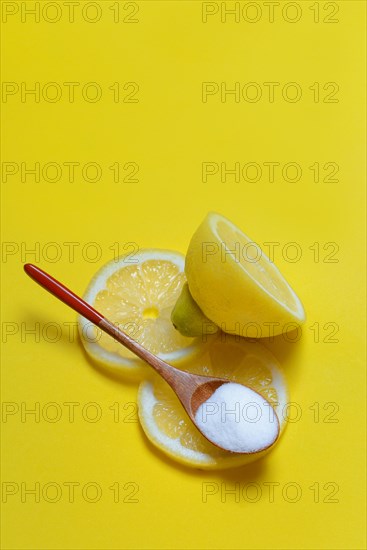 Citric acid in wooden spoon and lemon