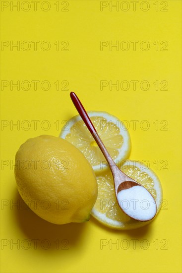 Citric acid in wooden spoon and lemon