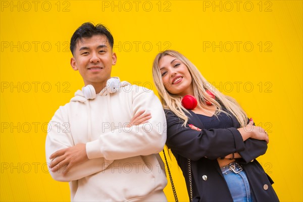 Portrait of a multiethnic couple of Asian man and Caucasian woman on a yellow background