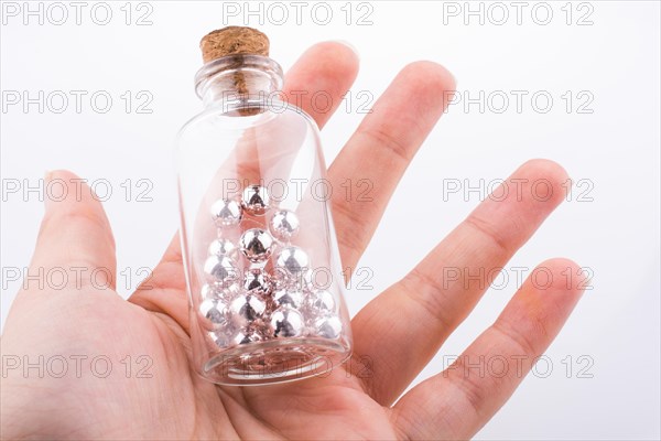 Little perfume glass bottle in hand on a white background