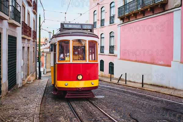 Famous vintage yellow tram 28 in the narrow streets of Alfama district in Lisbon