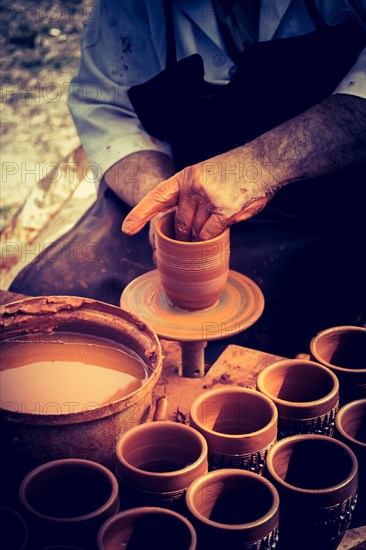 Potter`s hands shaping up the clay of the pot