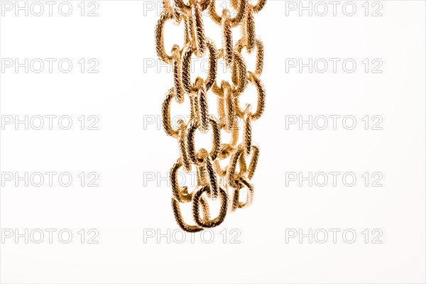 Gold color metal chain on white background