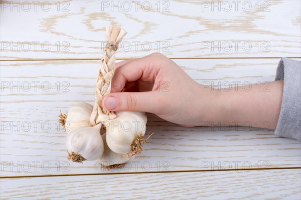 Hand holding cloves of garlic on a wooden texture